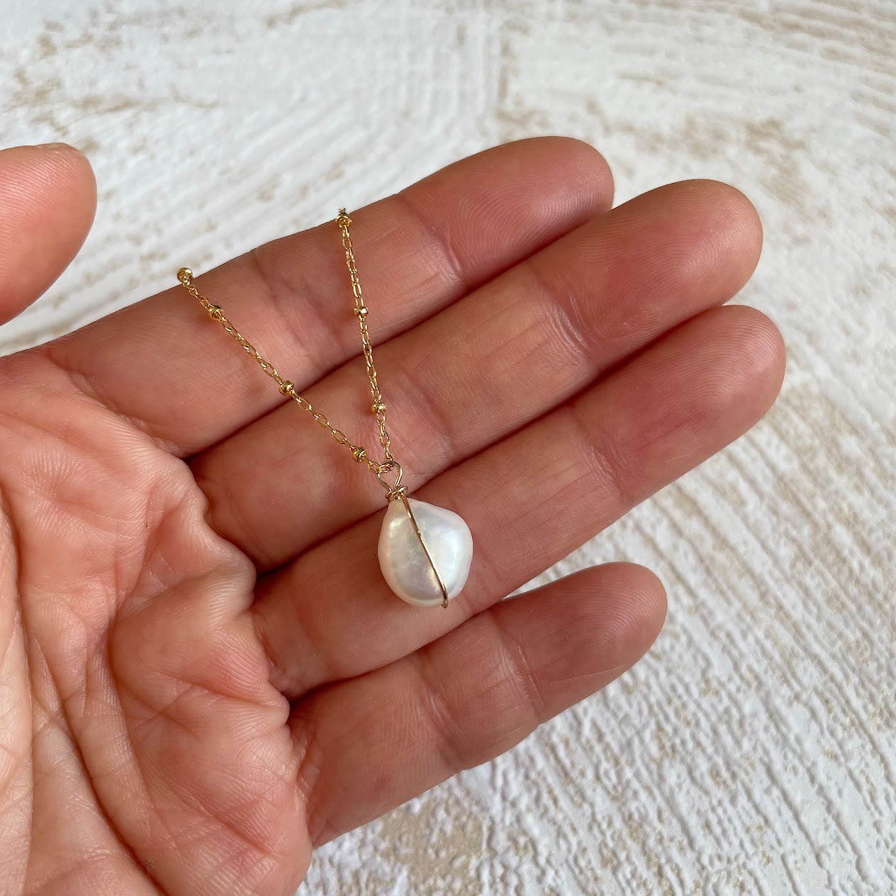 collier-pendentif-perle-blanche-odessa-main