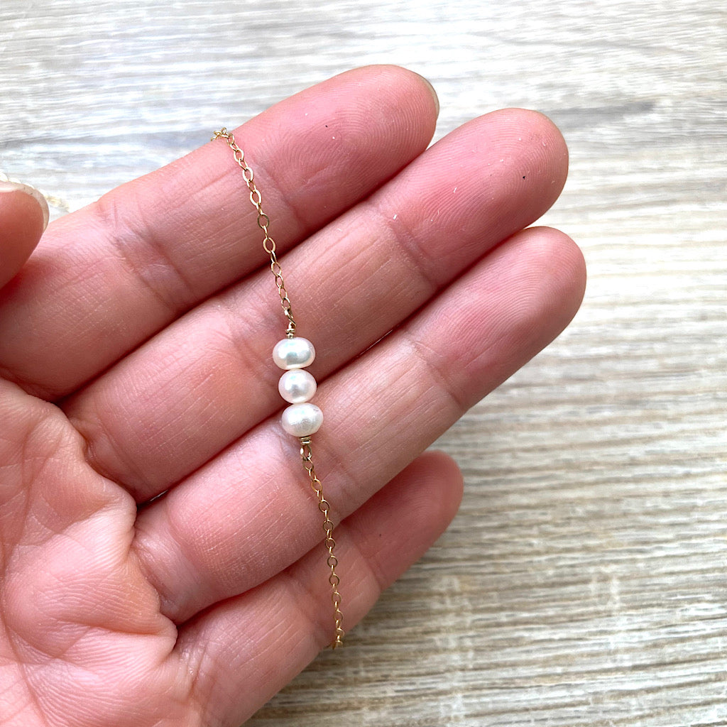 collier-mariage-dos-perles-mains